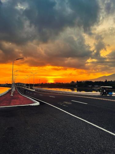 an empty highway with a sunset in the background at Fernando's Hotel in Sorsogon
