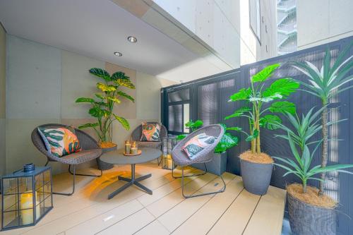 a room with chairs and a table and plants at Ken's Place Minami-Azabu in Tokyo