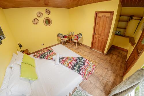 a bedroom with a bed and a table with chairs at La Casa del Molino Blanco B&B in Baños
