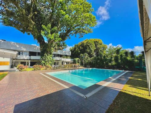 a swimming pool in a yard with a tree at Fernando's Hotel in Sorsogon