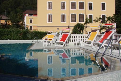 a group of lawn chairs sitting next to a swimming pool at Liberty Hotel Malé in Malè