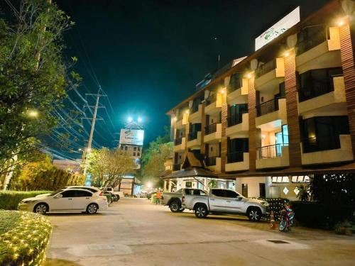 two cars parked in a parking lot in front of a building at khaoyai lumtakong hotel in Mu Si