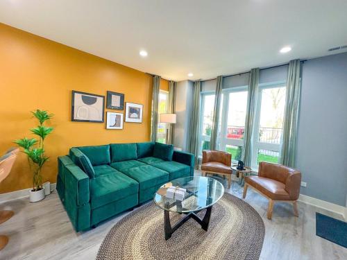 a living room with a green couch and a glass table at Spacious 3BR Family Oasis Sleeps 8 with Free Parking Near Medical District, Douglas Park and University of Illinois Chicago in Chicago