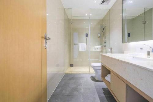 a bathroom with a shower and a toilet and a sink at City Comfort Inn Wuhan Wansongyuan Wangjiadun East Metro in Wuhan