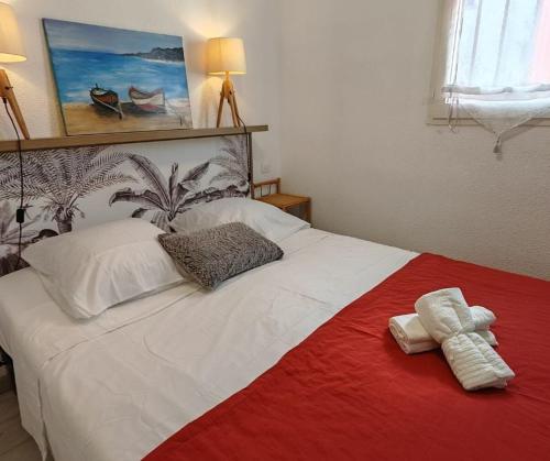 un lit blanc avec deux serviettes dessus dans l'établissement Les Patios de Toreilles, douce parenthèse, à Torreilles