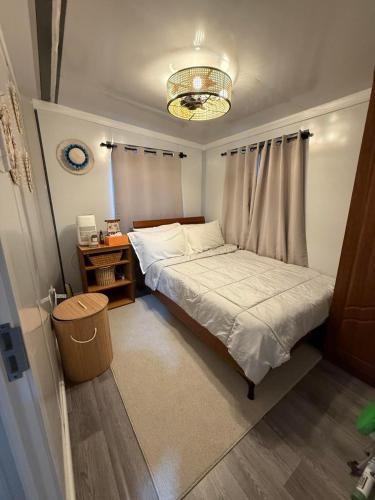 a small bedroom with a bed and a chandelier at Majuro Beachfront Container Home in Majuro
