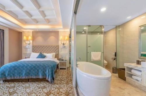 a hotel room with a bed and a bathtub and a bed and bathroom at Yantai Bihai Hotel in Yantai