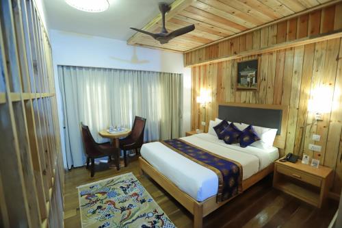 a bedroom with a bed and a table in a room at Hotel Phuntsho pelri in Thimphu