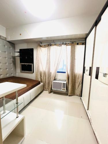 a bedroom with a bed and a tv in a room at Sea Residence MOA - Chrisdick in Manila