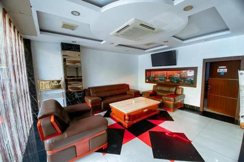 a living room with couches and a table and a tv at Lucky Star Hotel Near Harbour Bay Batam in Nagoya