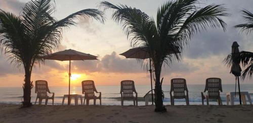 a group of chairs and umbrellas on a beach at Seascape Resort Baan Krood in Ban Krut