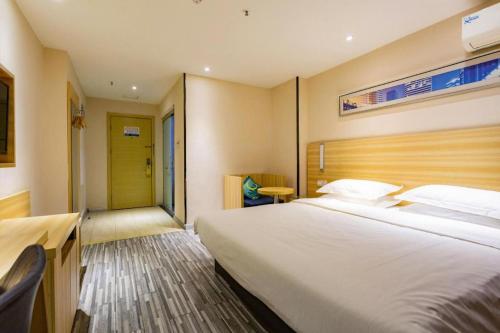 a bedroom with a large white bed in a room at City Comfort Inn Wuhan Hankou Railway Station West Square in Wuhan