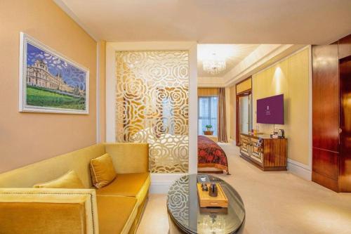 a living room with a couch and a bedroom at Fortune International Hotel in Xiawutun