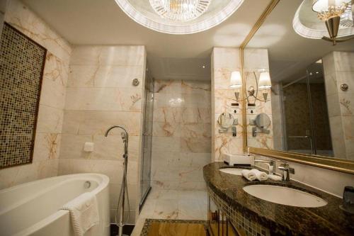 a bathroom with a tub and a sink and a bath tub at Fortune International Hotel in Xiawutun
