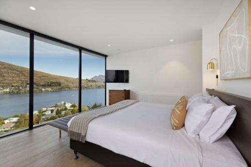 sypialnia z dużym łóżkiem i dużymi oknami w obiekcie The Bunkers Penthouse-2 Bed w mieście Queenstown