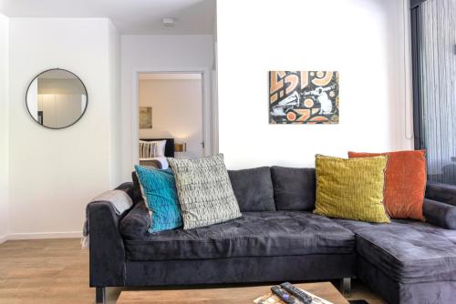 a living room with a gray couch with colorful pillows at Cosmo Stays- Designer Apartment Fabulous Location in Melbourne