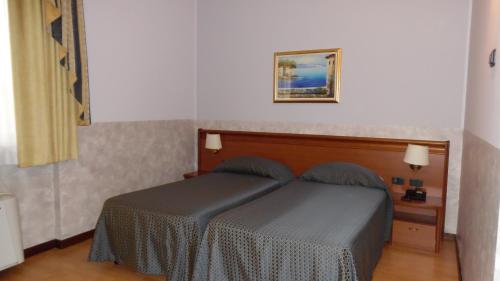 a bedroom with a bed and a picture on the wall at Hotel Majestic in San Giuliano Milanese