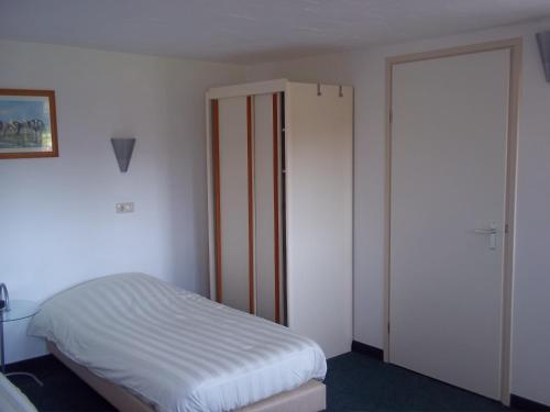 a bedroom with a bed and a closet at B&B Slaoperij in Orvelte