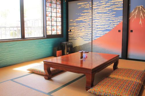 a room with a wooden table and a bench at Kujiranoonaka in Minamitsuru