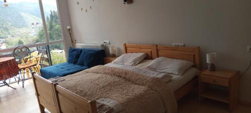 a bedroom with a bed and a large window at Ksenia's apartment in Borjomi