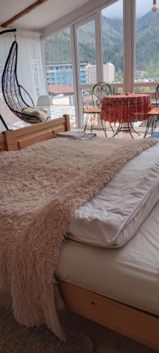 a bed in a room with a large window at Ksenia's apartment in Borjomi