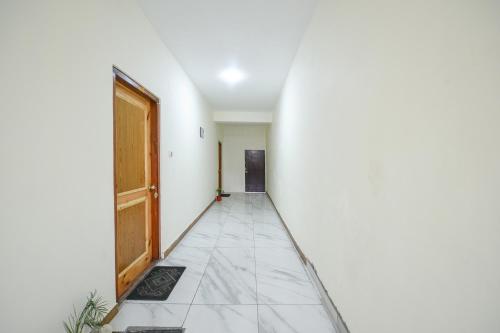 an empty hallway with a door and a tile floor at FabHotel Paradise Guest House in Kyelang