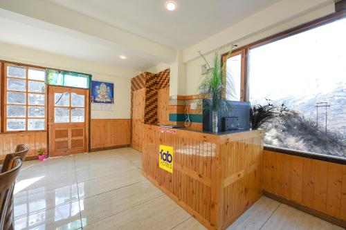 a living room with a large window and a table at FabHotel Paradise Guest House in Kyelang