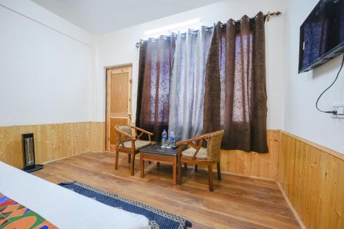 a room with a table and two chairs and a window at FabHotel Paradise Guest House in Kyelang