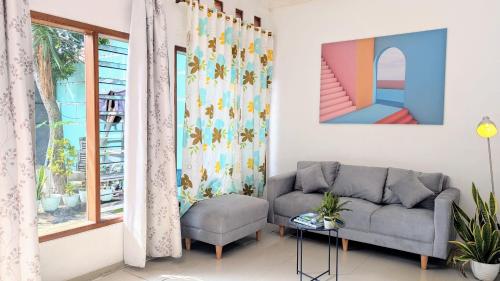 a living room with a couch and a window at Homey Guesthouse Kertajaya (Syariah) in Surabaya