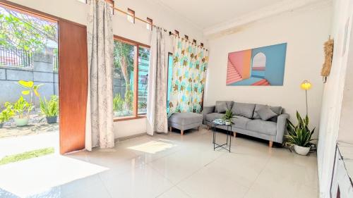 a living room with a couch and a window at Homey Guesthouse Kertajaya (Syariah) in Surabaya