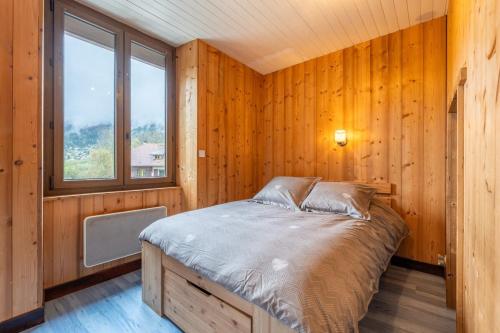 Ce lit se trouve dans une chambre en bois dotée d'une fenêtre. dans l'établissement Havre de paix entre Lac d'Annecy & Montagnes, à Alex