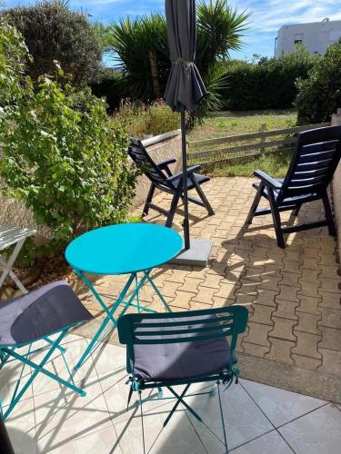 - une table, 2 chaises et un parasol sur la terrasse dans l'établissement Studio Arc-en-ciel, à Sète