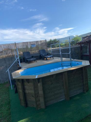 - une piscine sur une terrasse en bois avec 2 chaises dans l'établissement Chez Adeline Cévennes, à Ganges