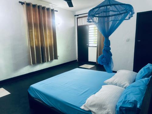 a bedroom with a blue bed and a window at Rock Hill Hotel in Galle