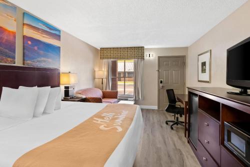 a hotel room with a bed and a flat screen tv at Days Inn by Wyndham Petersburg/South Fort Lee in Petersburg