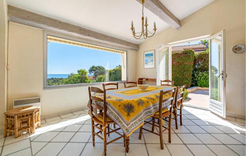 une salle à manger avec une table et des chaises et une grande fenêtre dans l'établissement Pet Friendly Home In Saint Aygulf, à Saint-Aygulf