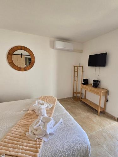 une chambre avec un lit et un miroir au mur dans l'établissement Les chambres des Saladelles, à La Celle-sous-Gouzon