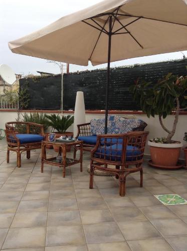 a patio with two chairs and a table and an umbrella at L'Approdo in San Leone