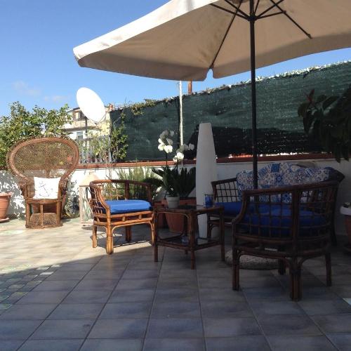 a patio with a table and chairs and an umbrella at L'Approdo in San Leone