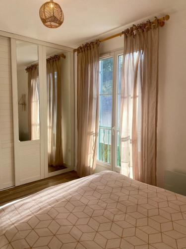 une chambre avec un grand lit et une grande fenêtre dans l'établissement Villa nichée sur golf & piscine, à Sainte-Maxime