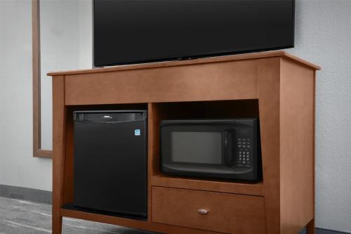 a tv on top of a wooden stand with a microwave at Hampton Inn Pittsburgh Greentree in Pittsburgh