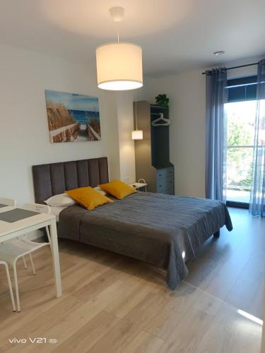 a bedroom with a bed and a table and a lamp at Villa Cork in Dębki