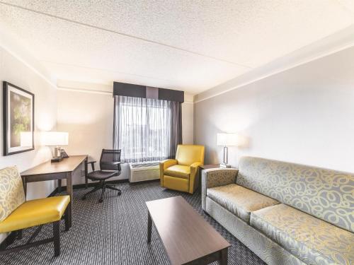 a hotel room with a couch and a table and chairs at La Quinta by Wyndham Austin Airport in Austin