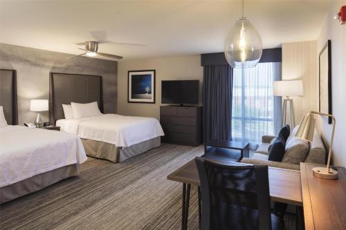 a hotel room with two beds and a desk at Homewood Suites by Hilton Needham Boston in Needham