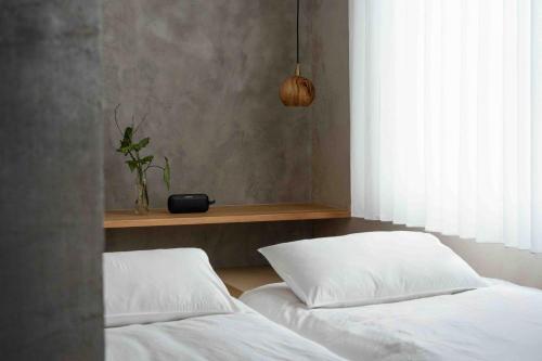 two white beds in a bedroom with a window at OR Inn Beipu in Beipu