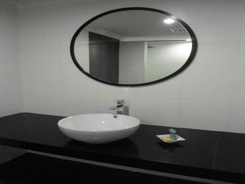 a bathroom with a sink and a mirror at Regent Hotel in Bintulu