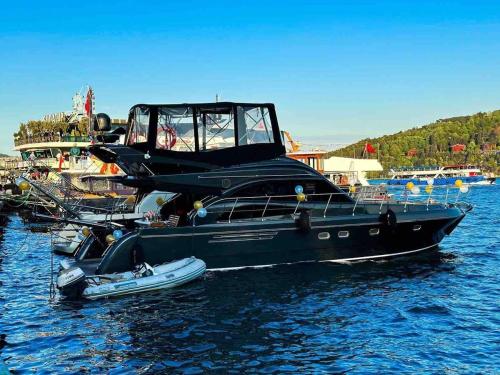 ein schwarzes Boot im Wasser mit einem kleinen Boot in der Unterkunft Den Den İstanbul in Istanbul