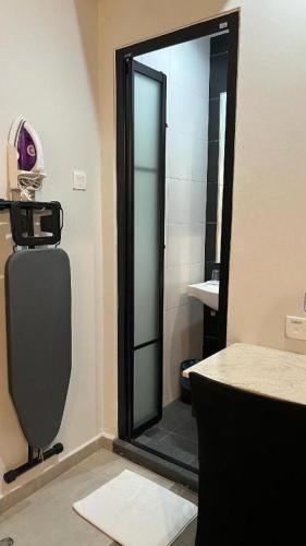 a bathroom with a shower with a mirror and a sink at In Trend Hotel in Cukai