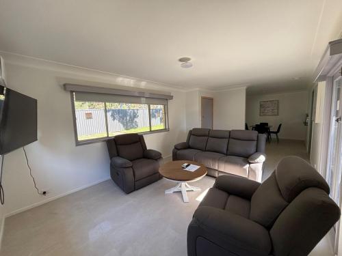 a living room with two couches and a table at Comfort Home Chermside West in Brisbane
