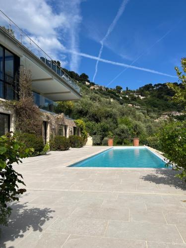 une piscine devant une maison dans l'établissement La perle - villa de luxe, à Villefranche-sur-Mer
